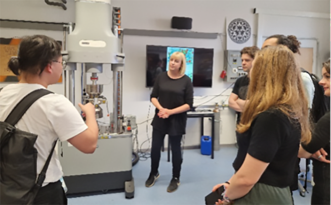 Jackie Kendrick discussing aspects of uniaxial compressive and tensile testing with the course participants during a lab tour
